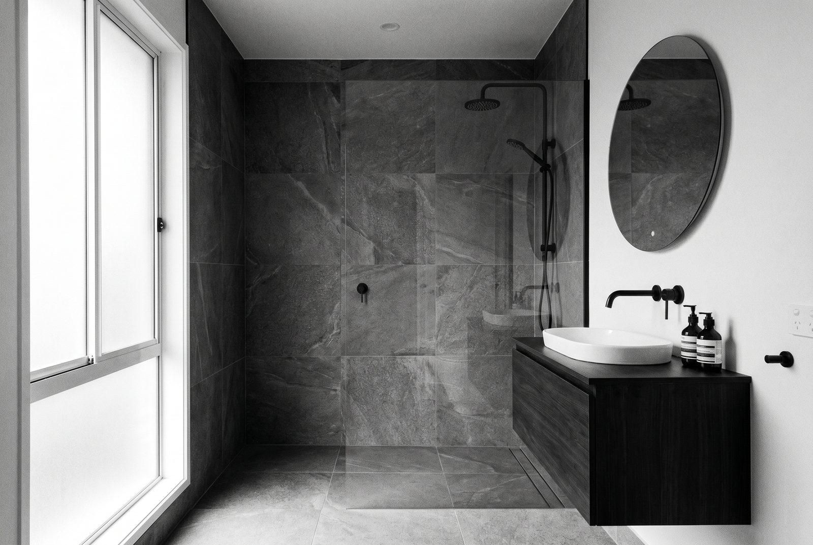 Modern saniertes Badezimmer mit bodenebener Dusche und Plattenbelag